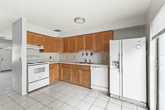 kitchen with white appliances, sink, and light tile patterned floors