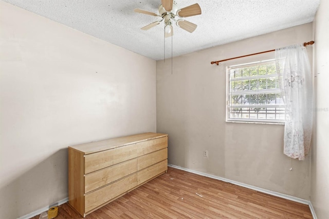 unfurnished bedroom featuring ceiling fan, light hardwood / wood-style floors, and a textured ceiling