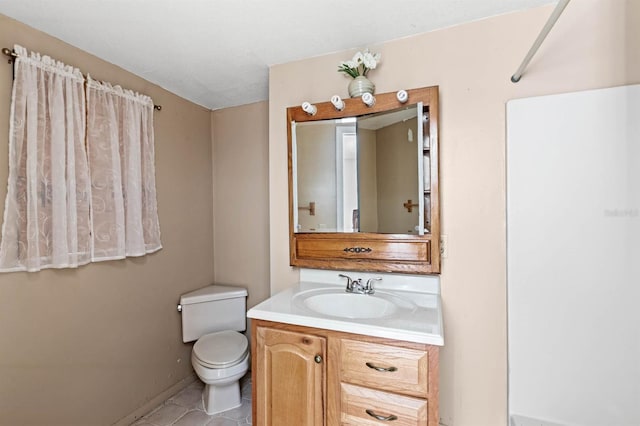 bathroom with tile patterned flooring, vanity, and toilet