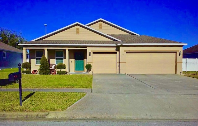 view of front of house with covered porch, a front yard, and a garage