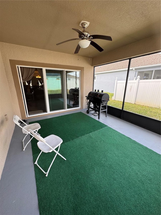 unfurnished sunroom featuring ceiling fan