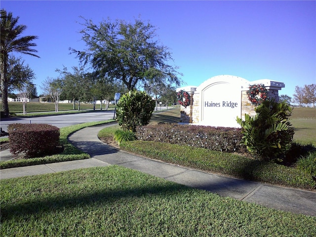 community / neighborhood sign featuring a yard