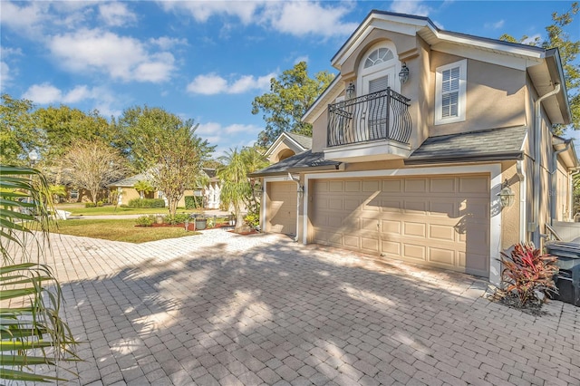 view of property exterior with a balcony and a garage