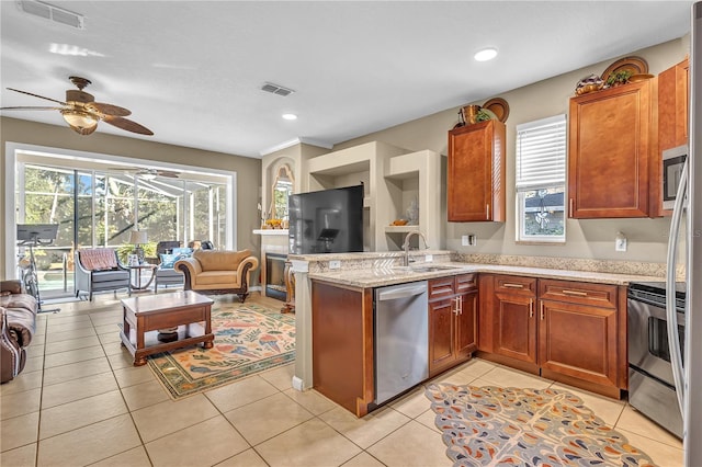 kitchen with kitchen peninsula, appliances with stainless steel finishes, ceiling fan, sink, and light tile patterned floors