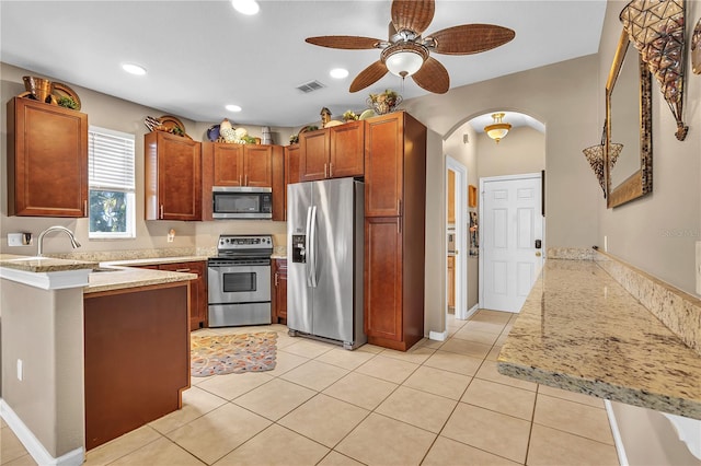 kitchen featuring ceiling fan, sink, stainless steel appliances, kitchen peninsula, and light tile patterned floors