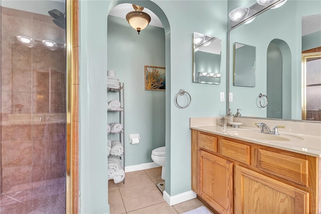 bathroom with walk in shower, tile patterned flooring, vanity, and toilet