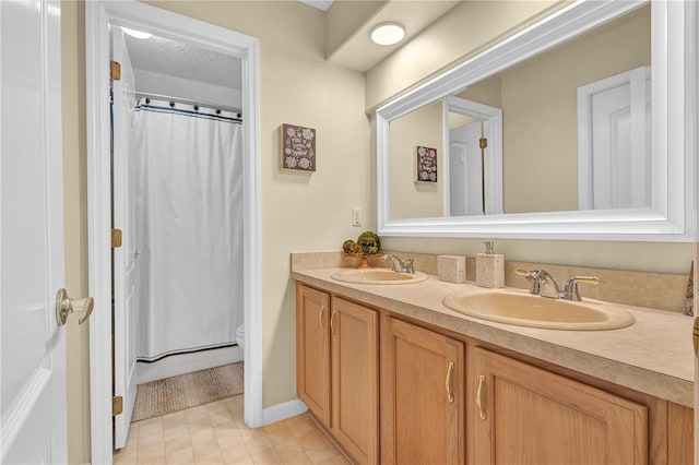 bathroom featuring a textured ceiling, vanity, and toilet