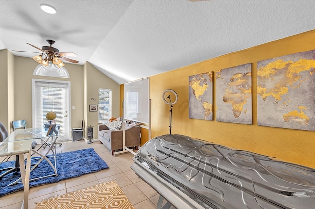 bedroom featuring light tile patterned floors, a textured ceiling, ceiling fan, and lofted ceiling