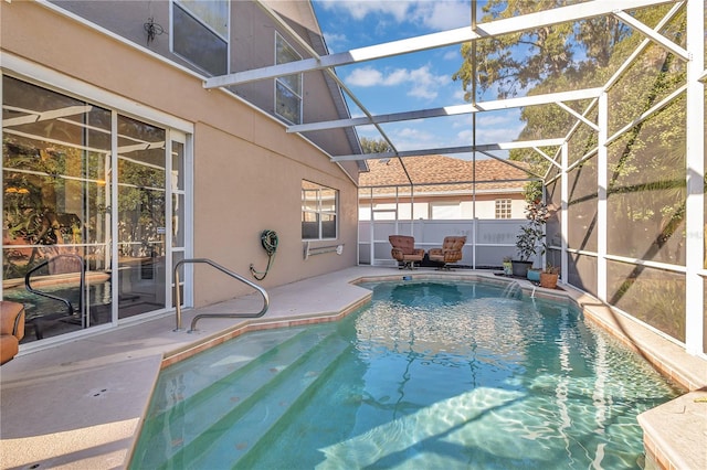 view of swimming pool with a patio area, pool water feature, and glass enclosure