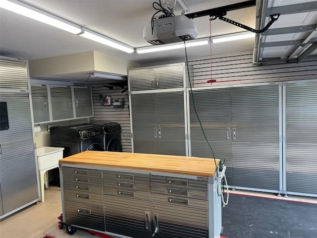 garage featuring independent washer and dryer and a garage door opener