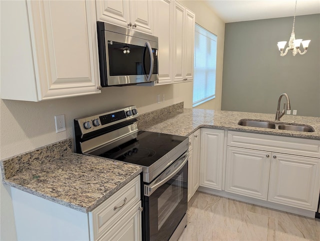 kitchen featuring white cabinets, sink, decorative light fixtures, stainless steel appliances, and a chandelier