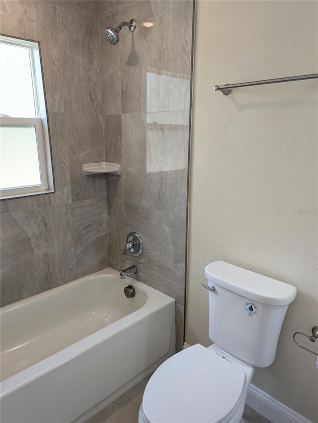 bathroom featuring tiled shower / bath combo and toilet