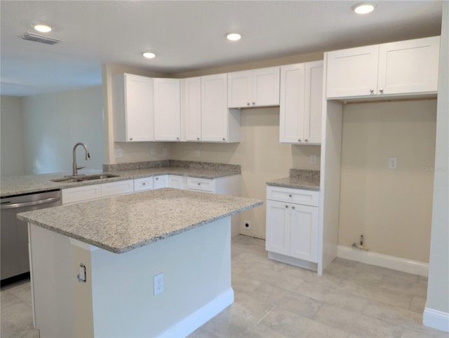 kitchen featuring dishwasher, white cabinets, a kitchen island, and sink