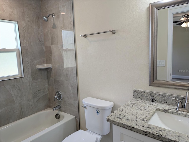 full bathroom with vanity, toilet, plenty of natural light, and tiled shower / bath