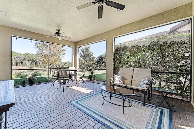 sunroom featuring ceiling fan