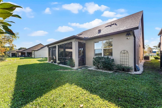 rear view of property with stucco siding, a shingled roof, a lawn, central AC unit, and a sunroom