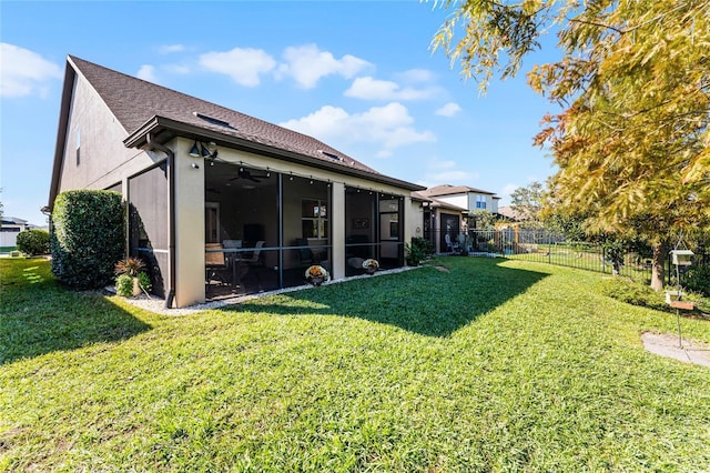 back of house with a ceiling fan, a lawn, a sunroom, fence private yard, and stucco siding