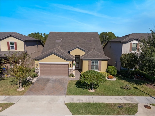 view of front facade featuring a garage, a shingled roof, stone siding, decorative driveway, and a front lawn