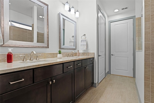 full bath featuring double vanity, visible vents, and a sink