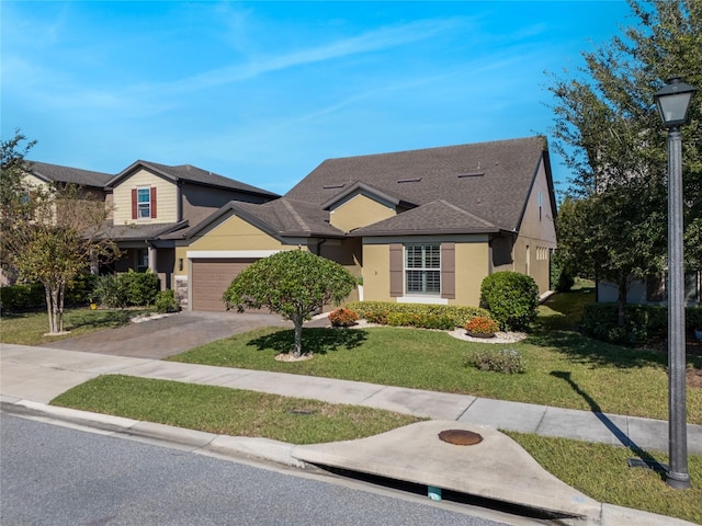 view of front of property featuring a garage, a shingled roof, driveway, stucco siding, and a front yard