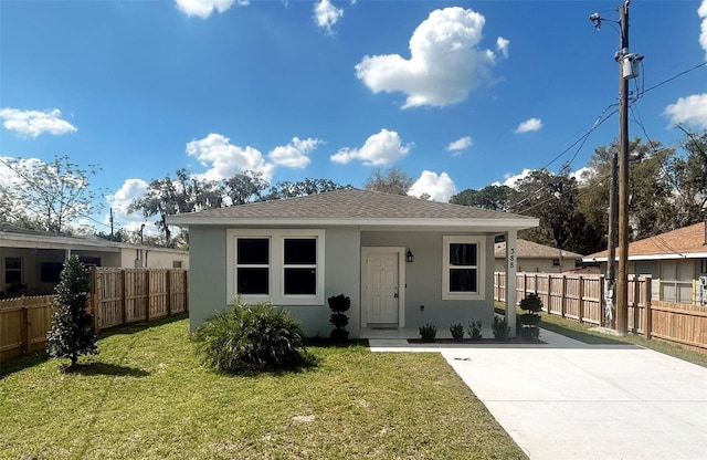 bungalow-style house featuring a shingled roof, a front yard, fence, and stucco siding