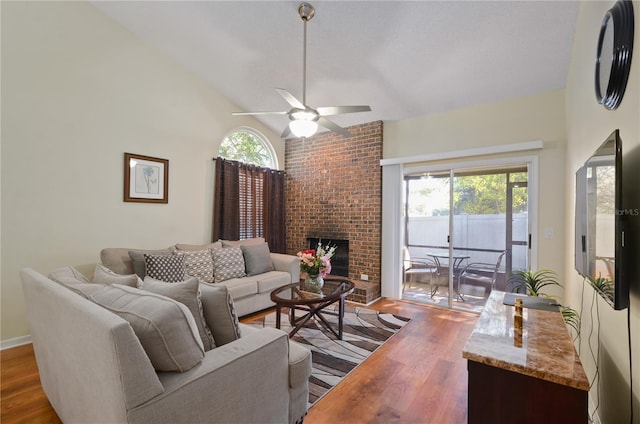 living room featuring dark hardwood / wood-style floors, ceiling fan, high vaulted ceiling, and a brick fireplace