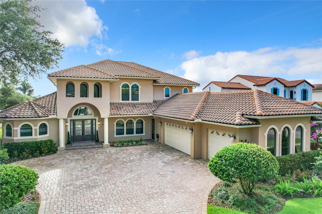 mediterranean / spanish house featuring french doors and a garage