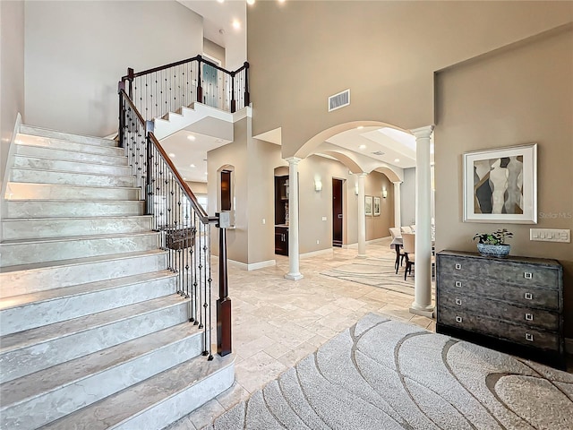 foyer featuring a high ceiling and ornate columns