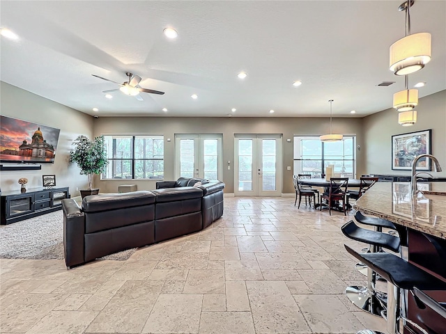 living room featuring ceiling fan, french doors, and a healthy amount of sunlight