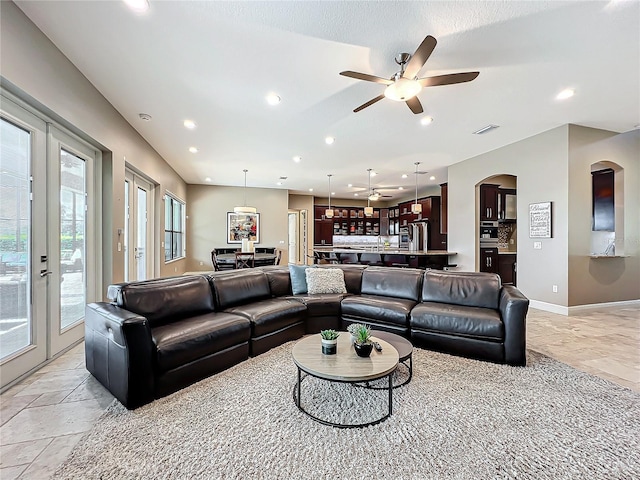 living room featuring ceiling fan and french doors