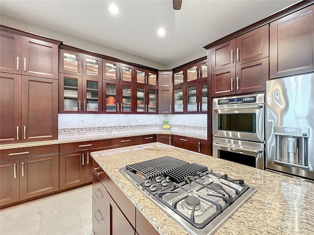 kitchen with light stone countertops and appliances with stainless steel finishes