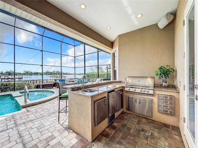 view of patio / terrace with glass enclosure, an outdoor kitchen, a water view, an outdoor wet bar, and a grill