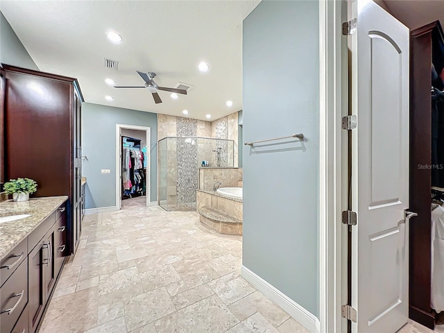 bathroom featuring ceiling fan, vanity, and independent shower and bath