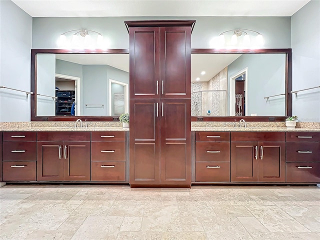 bathroom with vanity and a shower with door