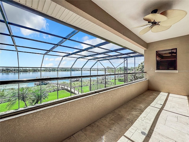 balcony with ceiling fan and a water view