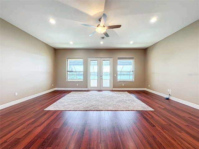 spare room with ceiling fan, plenty of natural light, dark wood-type flooring, and french doors