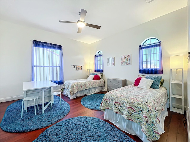 bedroom featuring ceiling fan, dark hardwood / wood-style flooring, and multiple windows