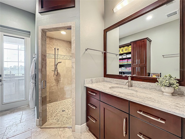 bathroom featuring vanity and a shower with door