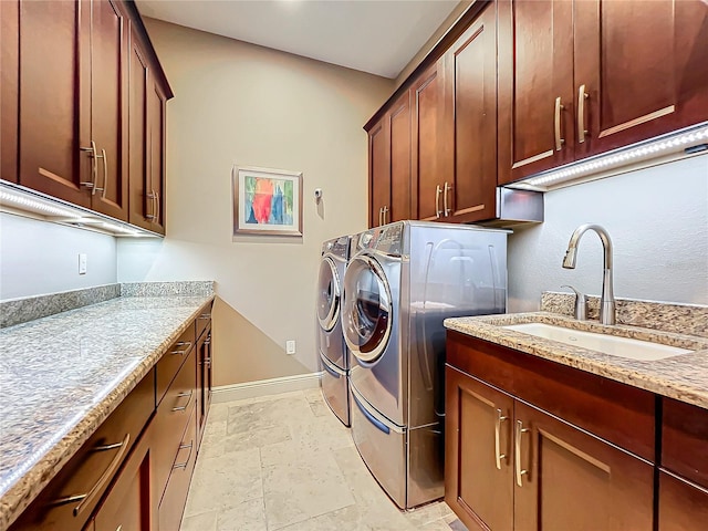 laundry room with cabinets, independent washer and dryer, and sink