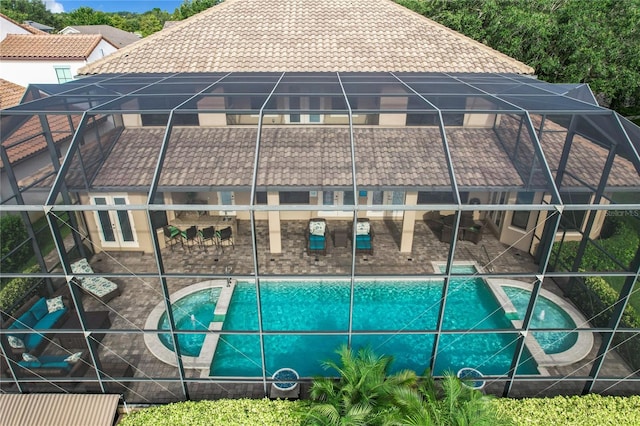 view of swimming pool with glass enclosure and a patio