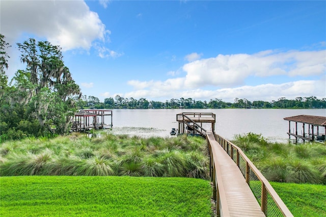 view of dock featuring a water view and a yard