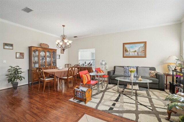 living room with hardwood / wood-style floors, a notable chandelier, and crown molding