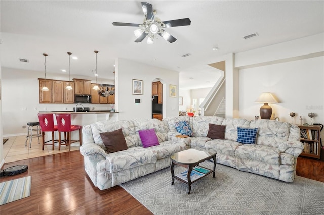 living room featuring hardwood / wood-style flooring, ceiling fan, and sink