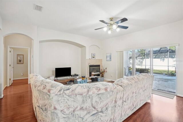 living room featuring ceiling fan and dark hardwood / wood-style flooring