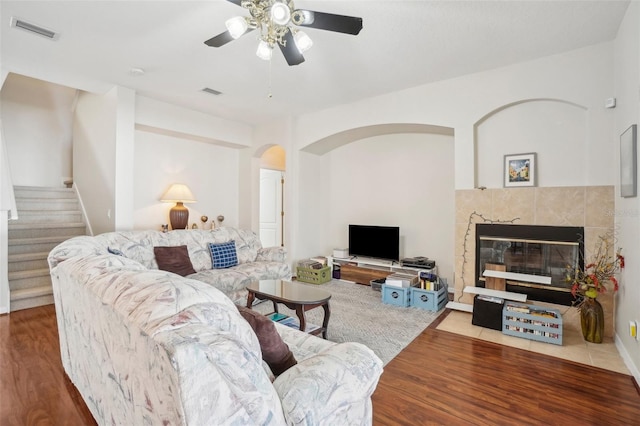 living room featuring a fireplace, hardwood / wood-style flooring, and ceiling fan