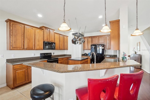 kitchen with black appliances, a kitchen island, and a kitchen bar