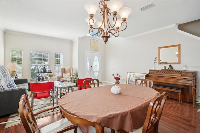 dining area featuring dark hardwood / wood-style flooring, crown molding, and a chandelier