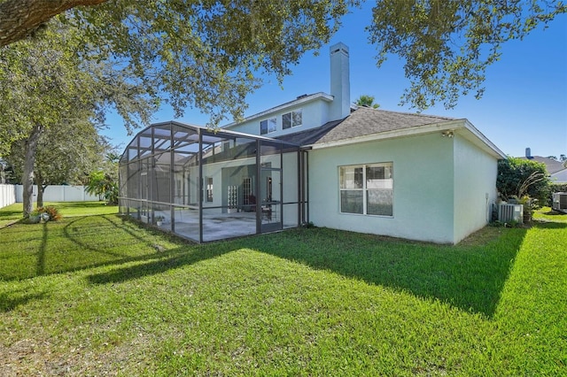 rear view of property featuring central AC unit, a patio area, a lanai, and a yard