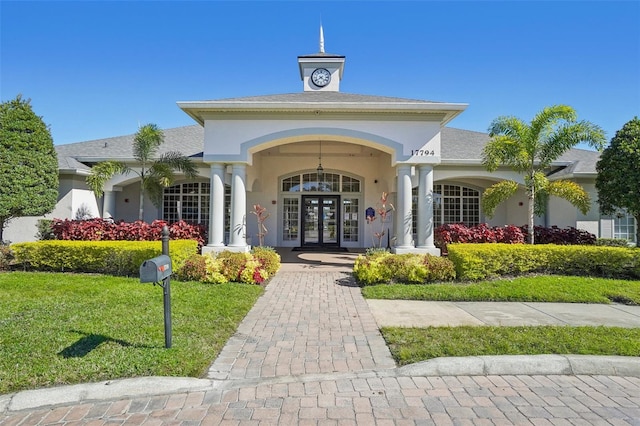 property entrance with a lawn and french doors