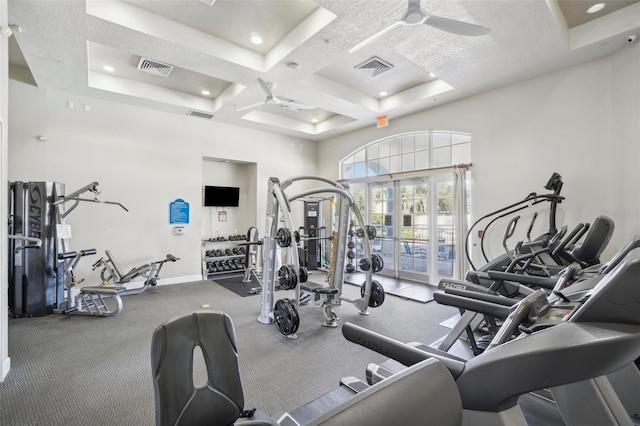 exercise room featuring ceiling fan and coffered ceiling